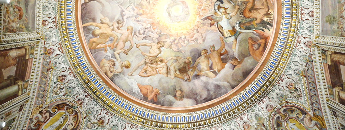 Palazzo Farnese di Caprarola. L'Anticamera degli angeli. La volta. La pittura illusionistica del Bertoja sfonda verso il cielo con la scena apocalittica della Caduta degli angeli ribelli. Sulla destra san Michele arcangelo che vince Lucifero. In basso il volto con le orecchie di asino è la firma, in forma di autoritratto, del Bertoja.