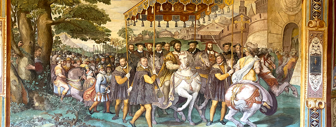 Palazzo Farnese di Caprarola. La Sala dei Fasti.L'Ingresso a Parigi di Carlo V. Il Gran Cardinal Farnese, con il cappello cardinalizio, si fece raffigurare sulla sinistra di Carlo V (sulla destra di chi guarda). Il pittore Taddeo Zuccari si è effigiato nelle sembianze del gentiluomo che tiene l'asta del baldacchino, sulla destra di chi guarda. Al lato opposto suo fratello, Federico.